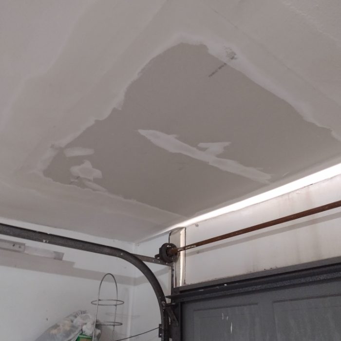 Water damage and staining visible on garage ceiling drywall