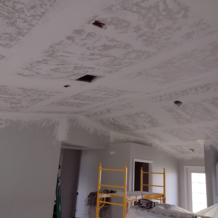 Interior ceiling under construction with drywall patches and yellow scaffolding ladder visible