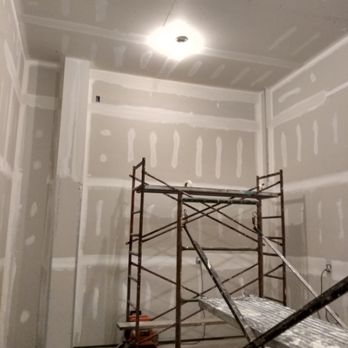 Interior drywall construction with metal scaffolding and recessed ceiling lighting