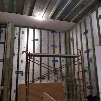 Interior drywall construction with metal studs and blue tape marking seams