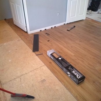 Flooring installation showing transition between cork and wood planks with tools nearby