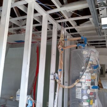 Interior room framing with white metal studs, glass panels, and construction materials visible inside