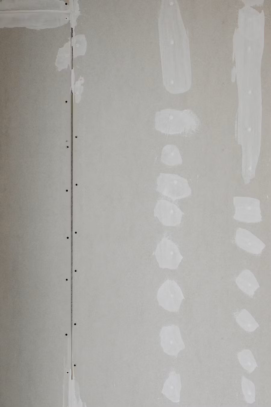 Drywall patched and taped seams with joint compound during interior wall renovation